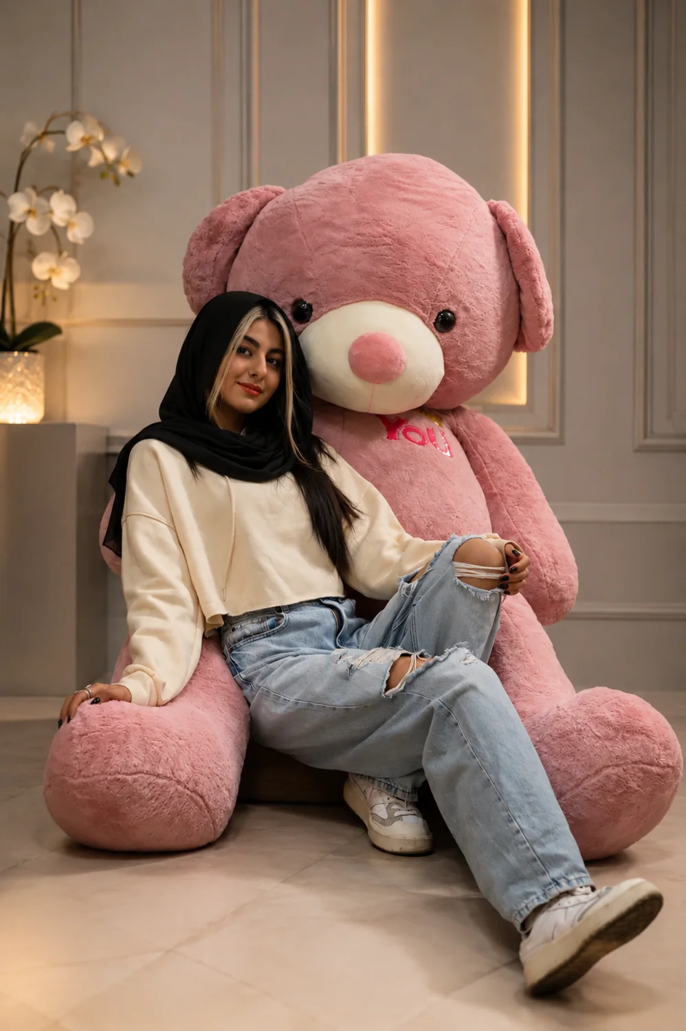 خرس کالباسی بزرگ تدی شاپ در کنار مدل برای نمایش ابعاد عروسک